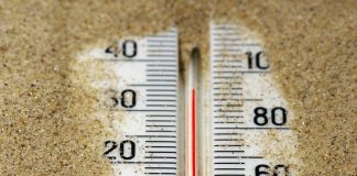 a close up of a thermometer in the sand
