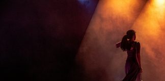 man in black jacket singing on stage