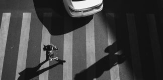 a black and white photo of a person crossing the street