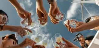 people holding clear glass bottles during daytime