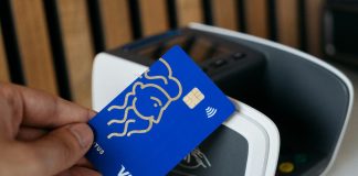 a person is holding a blue credit card