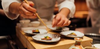 a person holding a chopstick over a plate of food