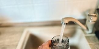a hand holding a glass of water