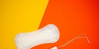 a pair of white shoes sitting on top of a red and yellow background